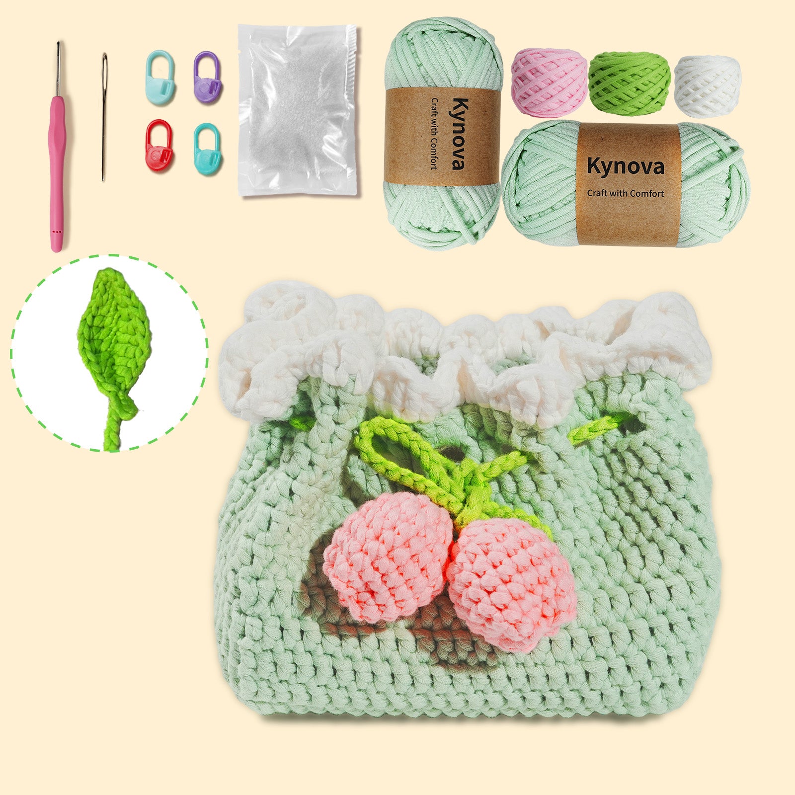 Crochet kit with yarn, hooks, accessorries and a light green tissue box cover with pink flowers on a beige background