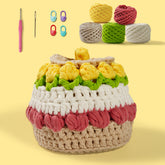 A Tulip Box Crochet Kit with various colored yarns, hooks, and other accessories displayed alongside a partially completed tulip box.