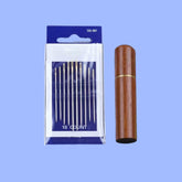 A 10-piece large-eye sewing needle set displayed in its packaging, which includes a blue card with needles arranged neatly on it, alongside a brown wooden storage box.