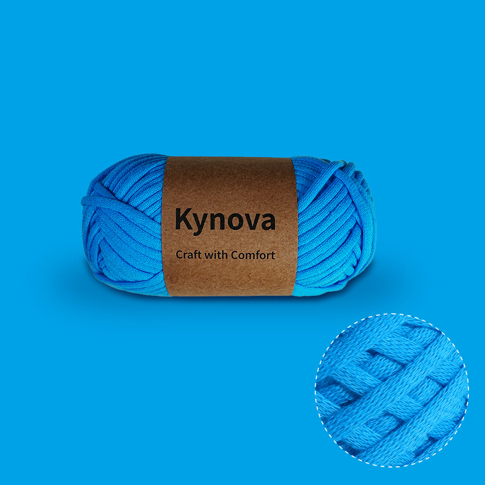 A skein of blue Kynova Premium Yarn with a label that reads 'Kynova Craft with Comfort', showing the yarn's texture and vibrant color.